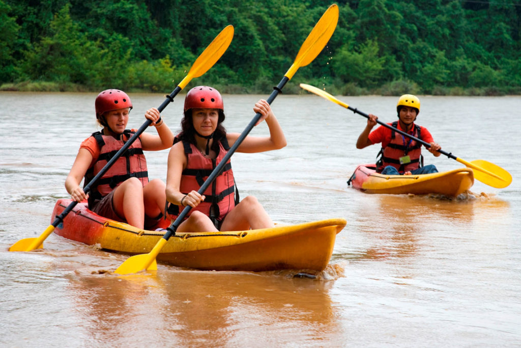 2 women kayak with a guide watching in another kayak