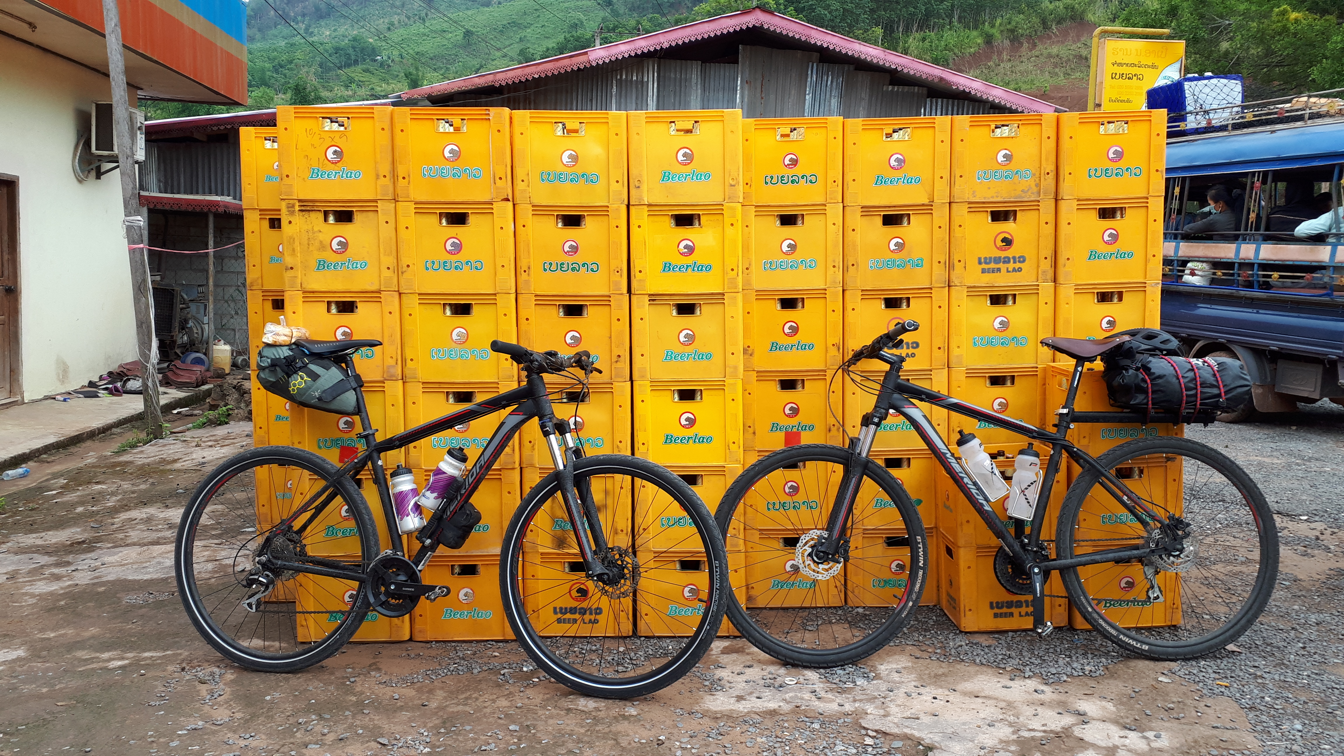 New mountain bikes Biking Laos in front of Beerlao crates